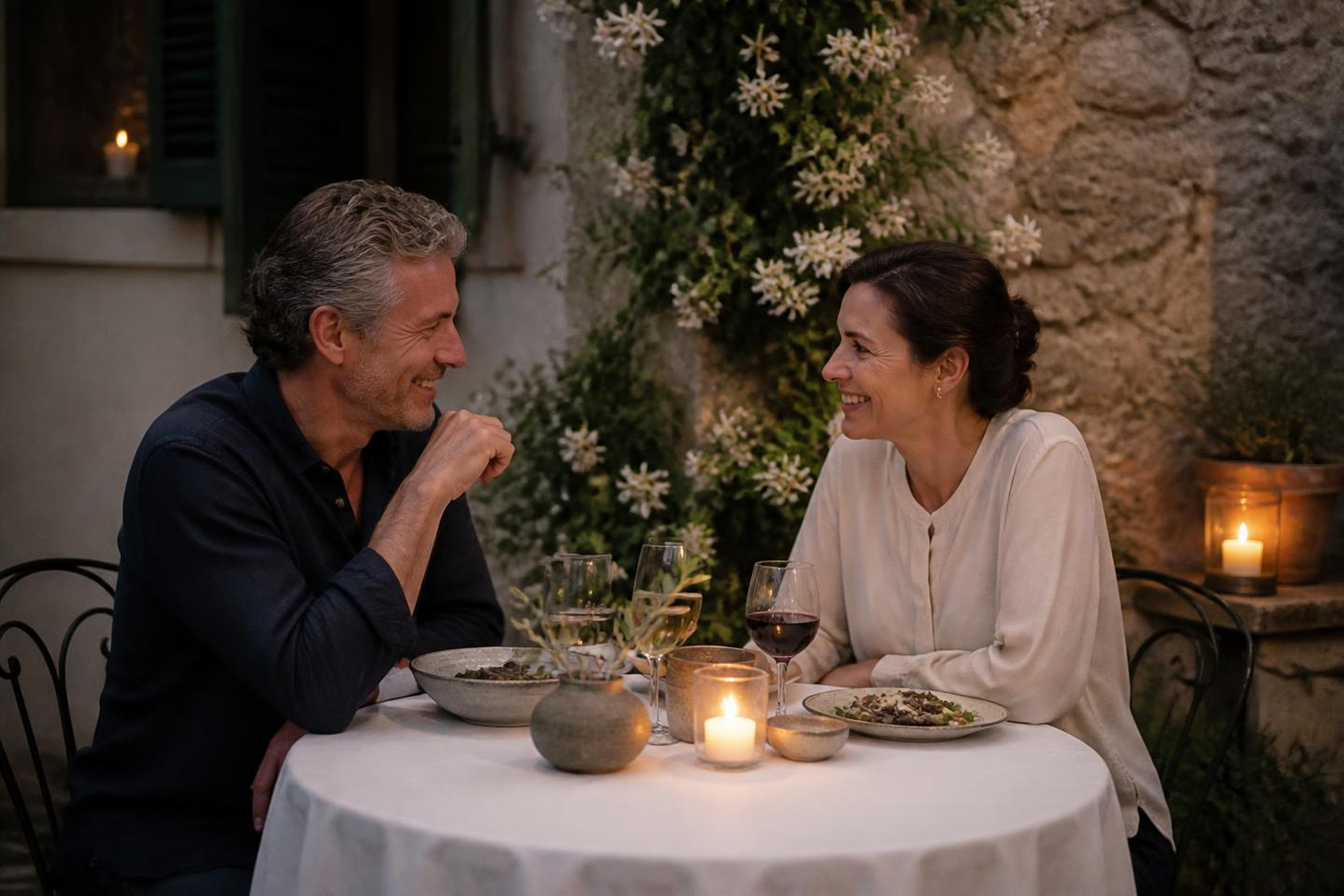 A couple talking over a candlelit dinner in a private courtyard